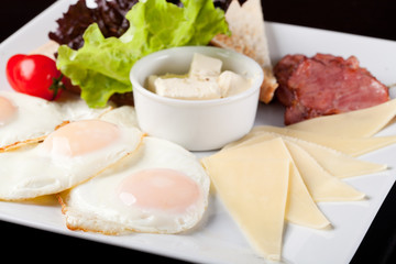 Breakfast fried eggs on a white plate
