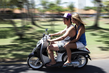 Happy couple traveling on moped