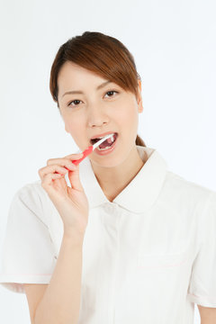 Beautiful young nurse cleaning teeth