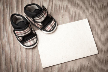 Baby shoes and blank paper