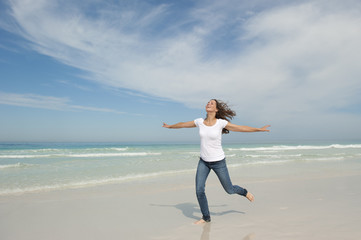 Fototapeta na wymiar Cute woman joyful running at beach