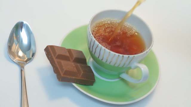 Pouring a cup of tea on the white background