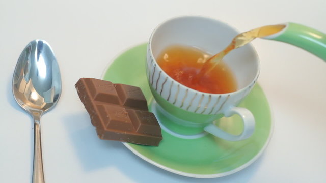 Pouring a cup of tea on the white background