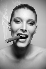 Attractive young woman smoking a cigar