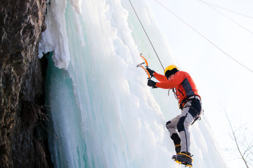 Man climbing frozen waterfall