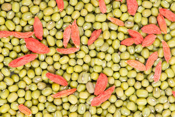 Green mung beans with red chinese wolfberry fruit background