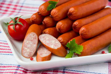 Sausages on plate with cherry tomato