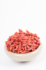 dried wolfberry fruit in bowl on white background