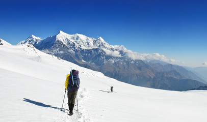 Lonely trekkers on big snow fieldsin Himalaya