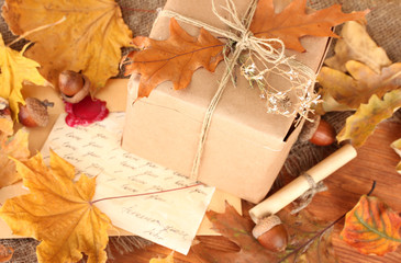 autumn background: vintage gift, letter and leaves