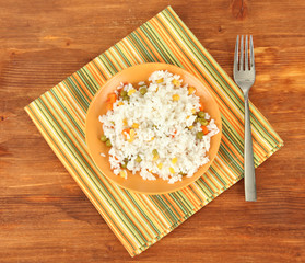 Risotto on color plate on wooden background