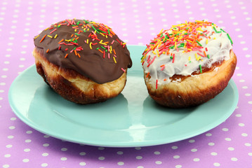 Tasty donuts on color plate on color background