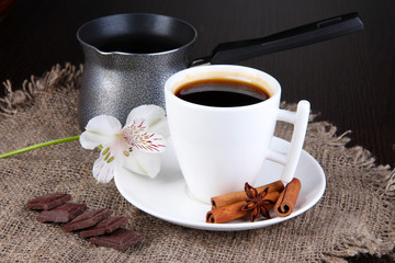 White cup of Turkish coffee with coffee maker on wooden table