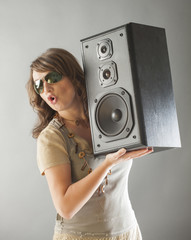 Beautiful woman holding big wooden speaker