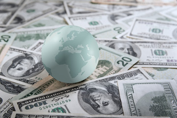 Earth globe on heap of money