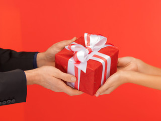 man and woman's hands with gift box
