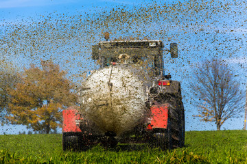 Naklejka premium Traktor düngt mit Gülle ein Feld