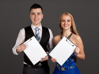 Young man and woman holding clip boards