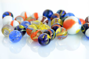A handful of colorful glass marbles on a white background.