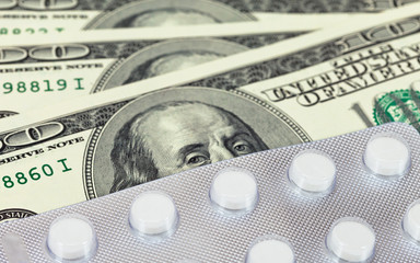 Closeup pills against money background