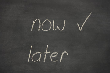 Fototapeta premium now later written on a chalk board / blackboard