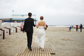 Hochzeitspaar geht am Strand spazieren