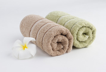 Towels rolled up and flower on white background