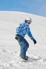 Fototapeta na wymiar Snowboarder ześlizguje śnieżnym stoku na snowboardzie.
