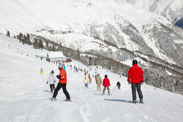 Fototapeta na wymiar Narciarze zejść ze wzgórza do wyciągu narciarskiego