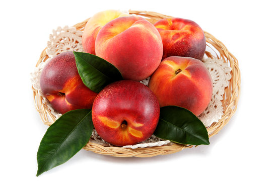 Fresh peaches and nectarines in a basket isolated on a white bac