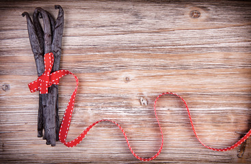 Red ribbon wraped around vanilla pods