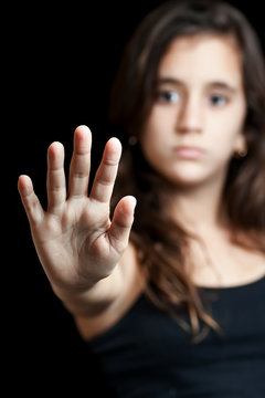 Hispanic girl with a hand extended signaling to stop