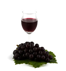 Red grape with green leaf  and a glass of red wine isolated on w