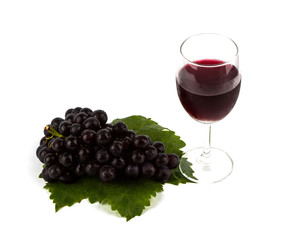 Red grape with green leaf  and a glass of red wine isolated on w