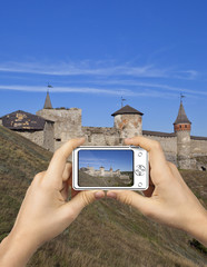 Tourist Holds Up Camera at Castle in Kamenets-Podolsky.