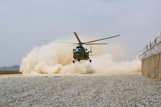 helicopter landing in cloud of dust on desert