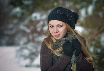 Happy girl with cap and gloves playing with snow in the winter l