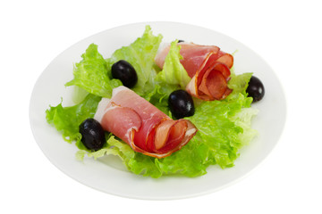 prosciutto with lettuce and olives on the plate