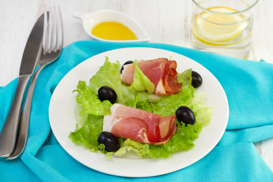 salad with prosciutto on the white plate