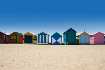 Fototapeta na wymiar Jasne i kolorowe domy na białym piasku plaży