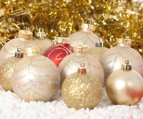 Red and gold Christmas baubles on golden background 