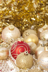 Red and gold Christmas baubles on golden background 