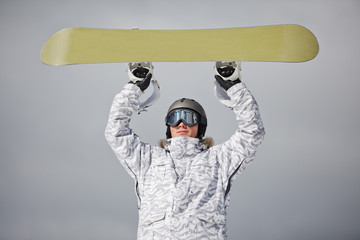 male snowboarder against sun and blue sky