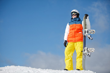 female snowboarder against sun and blue sky