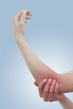 Acute pain in a woman elbow. Female holding hand to spot of elbo