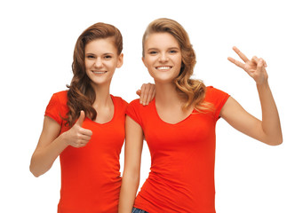 teenage girls showing thumbs up and victory sign