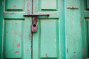 Key lock on green wooden wall