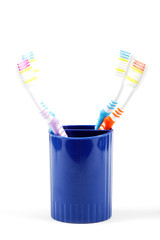 Toothbrushes in cup, isolated on white background