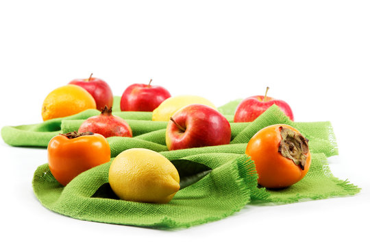 Set of different fresh fruits on green cloth.