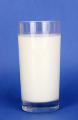 Glass of fresh new milk on blue background
